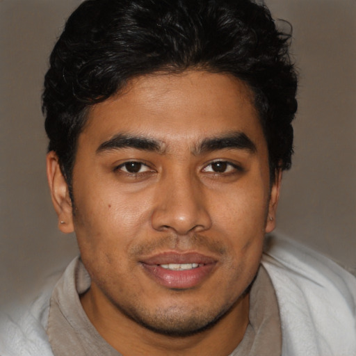 Joyful latino young-adult male with short  brown hair and brown eyes