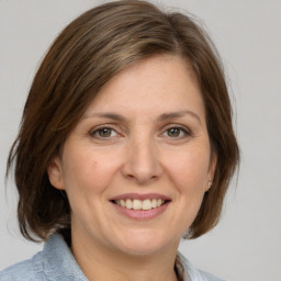 Joyful white adult female with medium  brown hair and grey eyes