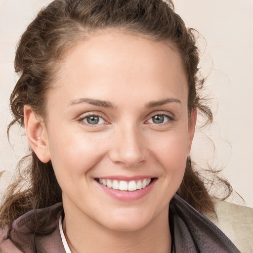 Joyful white young-adult female with medium  brown hair and grey eyes