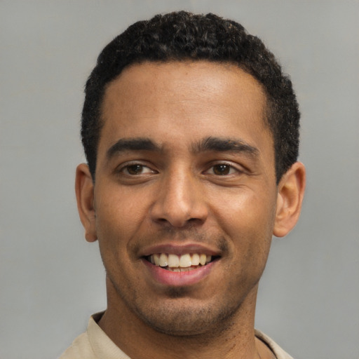 Joyful latino young-adult male with short  black hair and brown eyes