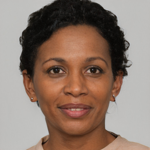 Joyful black adult female with short  black hair and brown eyes