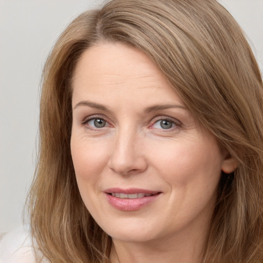 Joyful white adult female with long  brown hair and grey eyes