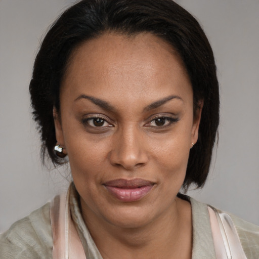 Joyful black adult female with medium  brown hair and brown eyes