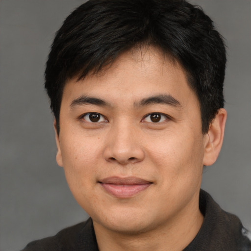 Joyful asian young-adult male with short  brown hair and brown eyes