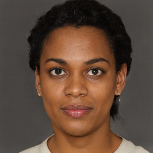 Joyful black young-adult female with short  black hair and brown eyes