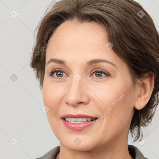 Joyful white adult female with medium  brown hair and brown eyes