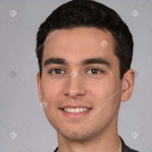 Joyful white young-adult male with short  black hair and brown eyes