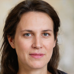 Joyful white young-adult female with medium  brown hair and green eyes