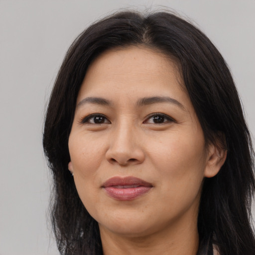 Joyful asian adult female with long  brown hair and brown eyes