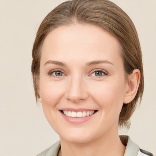 Joyful white young-adult female with medium  brown hair and green eyes