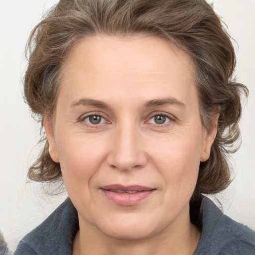 Joyful white adult female with medium  brown hair and grey eyes