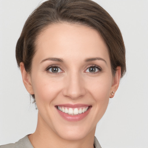 Joyful white young-adult female with short  brown hair and grey eyes