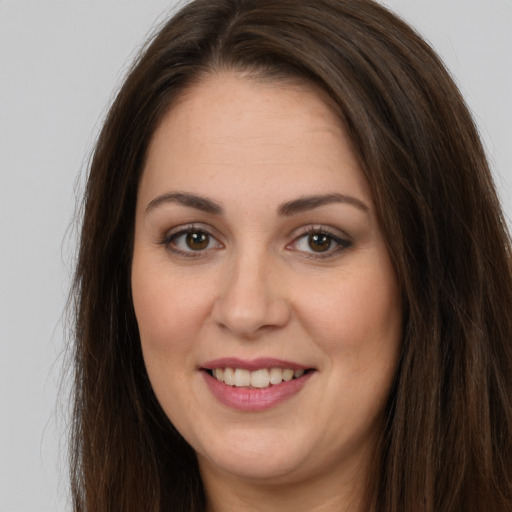 Joyful white young-adult female with long  brown hair and brown eyes