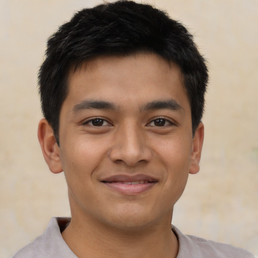 Joyful latino young-adult male with short  brown hair and brown eyes