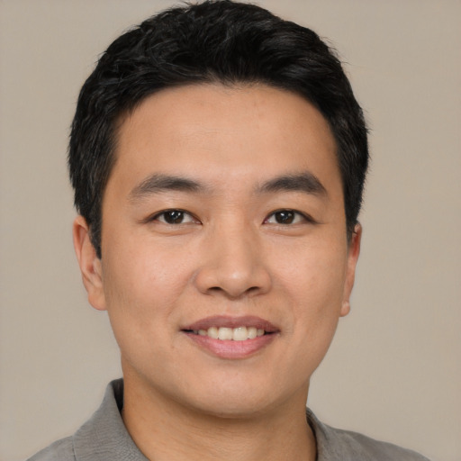 Joyful asian young-adult male with short  black hair and brown eyes
