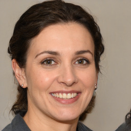 Joyful white adult female with medium  brown hair and brown eyes