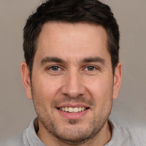 Joyful white adult male with short  brown hair and brown eyes