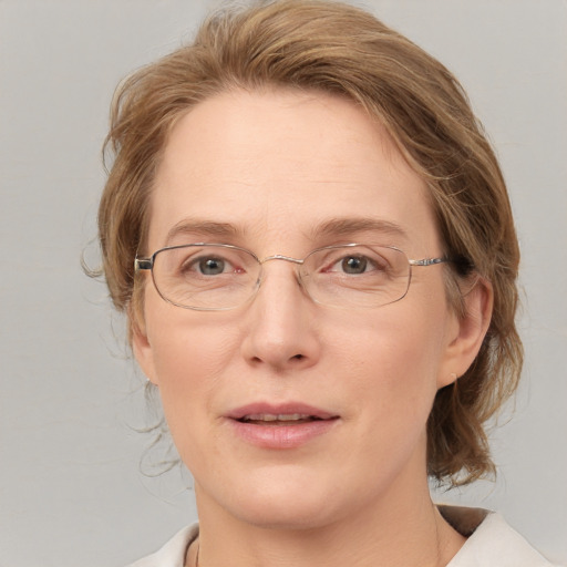 Joyful white adult female with medium  brown hair and blue eyes