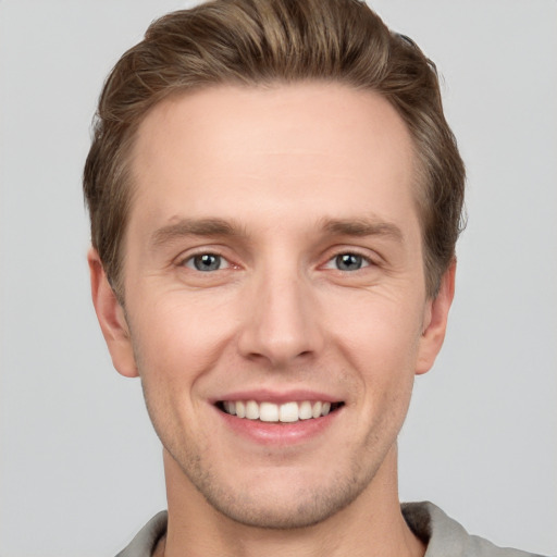 Joyful white young-adult male with short  brown hair and grey eyes