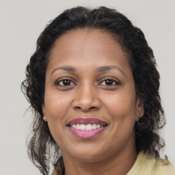 Joyful black adult female with medium  brown hair and brown eyes