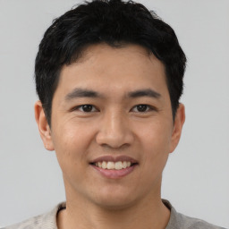 Joyful asian young-adult male with short  black hair and brown eyes