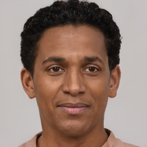 Joyful black young-adult male with short  black hair and brown eyes