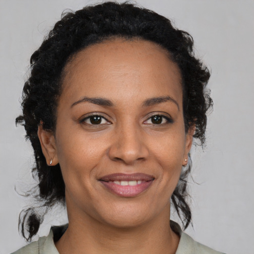 Joyful black adult female with medium  brown hair and brown eyes