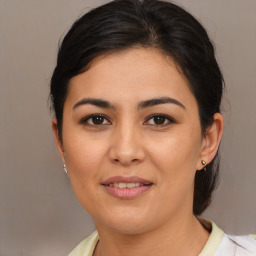 Joyful latino young-adult female with medium  brown hair and brown eyes