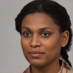 Joyful black young-adult female with long  brown hair and brown eyes