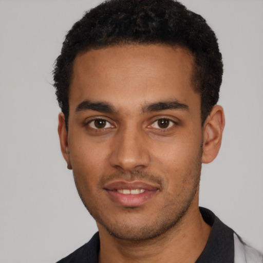 Joyful black young-adult male with short  black hair and brown eyes