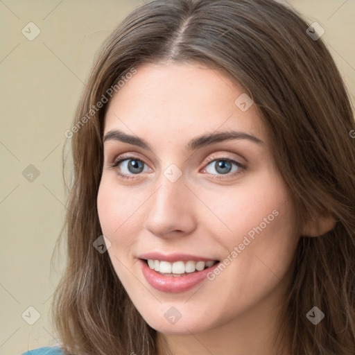 Joyful white young-adult female with long  brown hair and green eyes