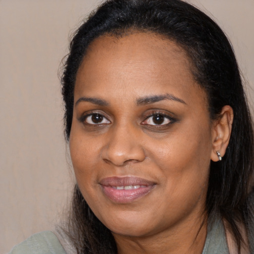Joyful black young-adult female with long  brown hair and brown eyes
