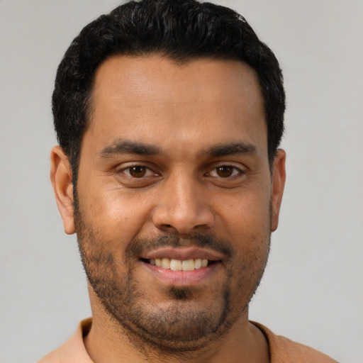 Joyful latino young-adult male with short  black hair and brown eyes