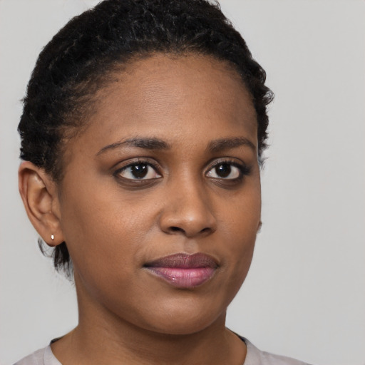 Joyful black young-adult female with short  brown hair and brown eyes
