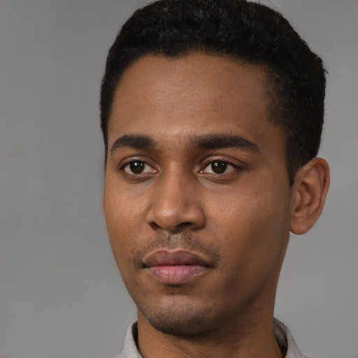 Joyful black young-adult male with short  black hair and brown eyes