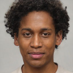 Joyful black young-adult male with short  brown hair and brown eyes