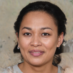 Joyful latino adult female with medium  brown hair and brown eyes