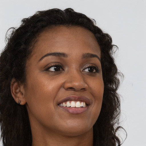 Joyful black young-adult female with long  brown hair and brown eyes