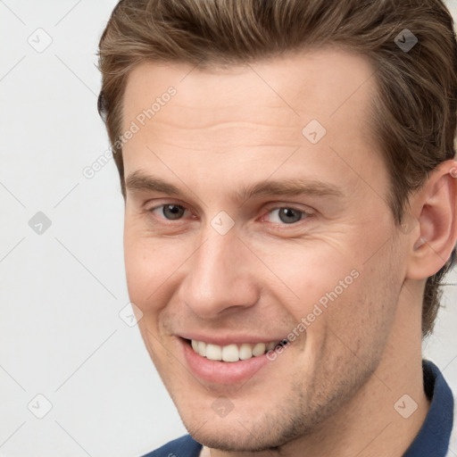 Joyful white young-adult male with short  brown hair and grey eyes