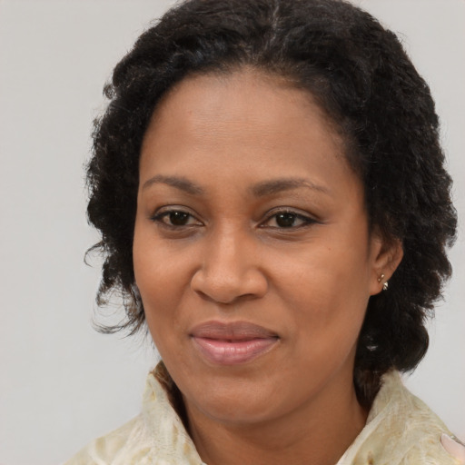 Joyful black adult female with medium  brown hair and brown eyes