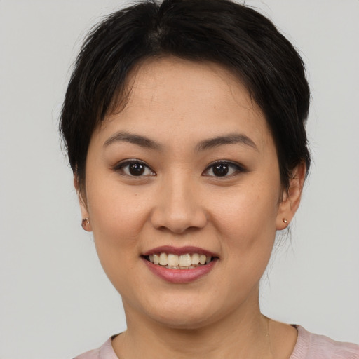 Joyful asian young-adult female with short  brown hair and brown eyes