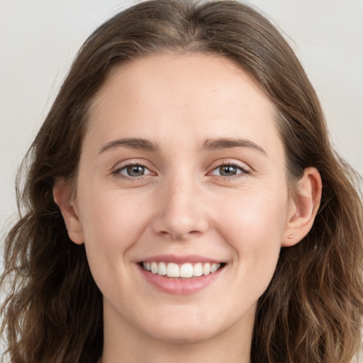 Joyful white young-adult female with long  brown hair and grey eyes