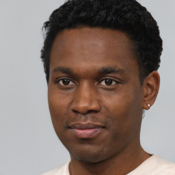 Joyful black young-adult male with short  black hair and brown eyes