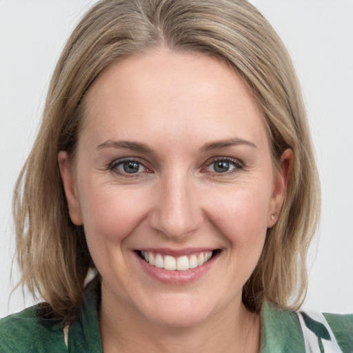 Joyful white young-adult female with medium  brown hair and blue eyes