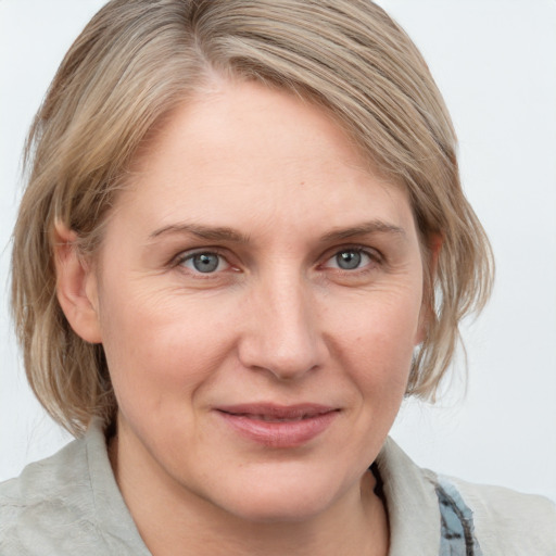 Joyful white adult female with medium  brown hair and grey eyes