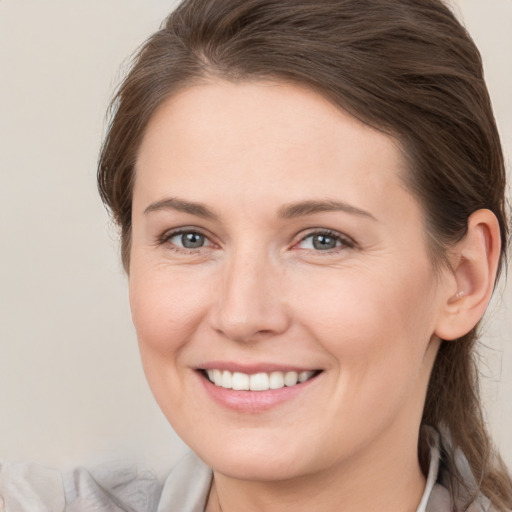 Joyful white young-adult female with medium  brown hair and grey eyes