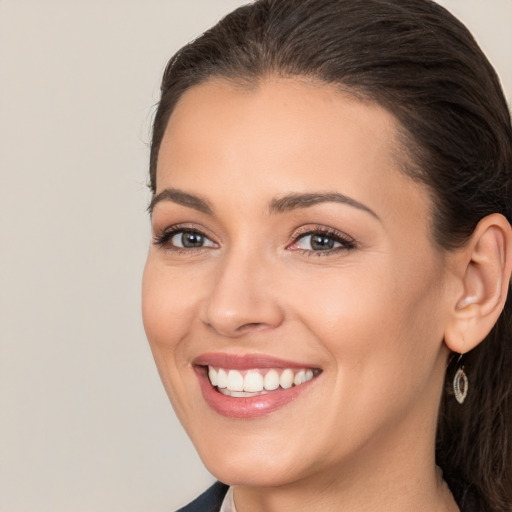 Joyful white young-adult female with long  brown hair and brown eyes