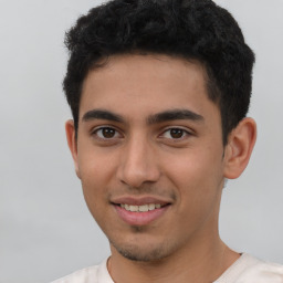 Joyful latino young-adult male with short  brown hair and brown eyes