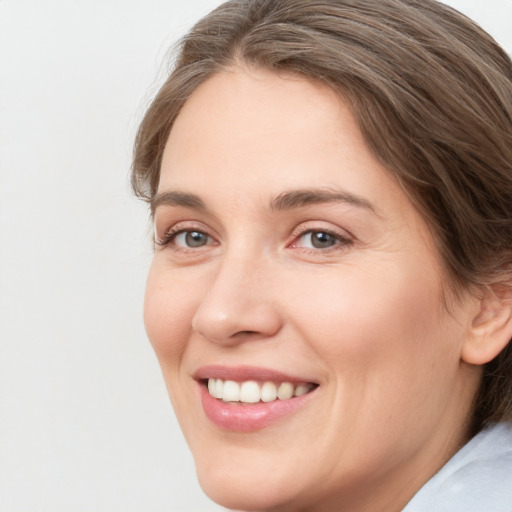 Joyful white young-adult female with medium  brown hair and green eyes