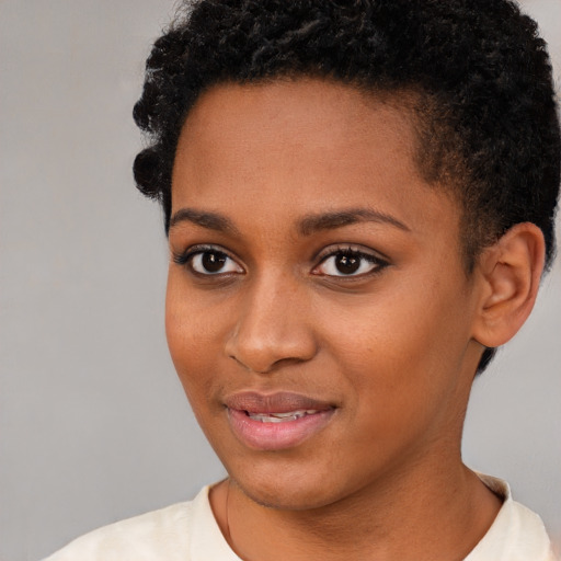 Joyful black young-adult female with short  brown hair and brown eyes